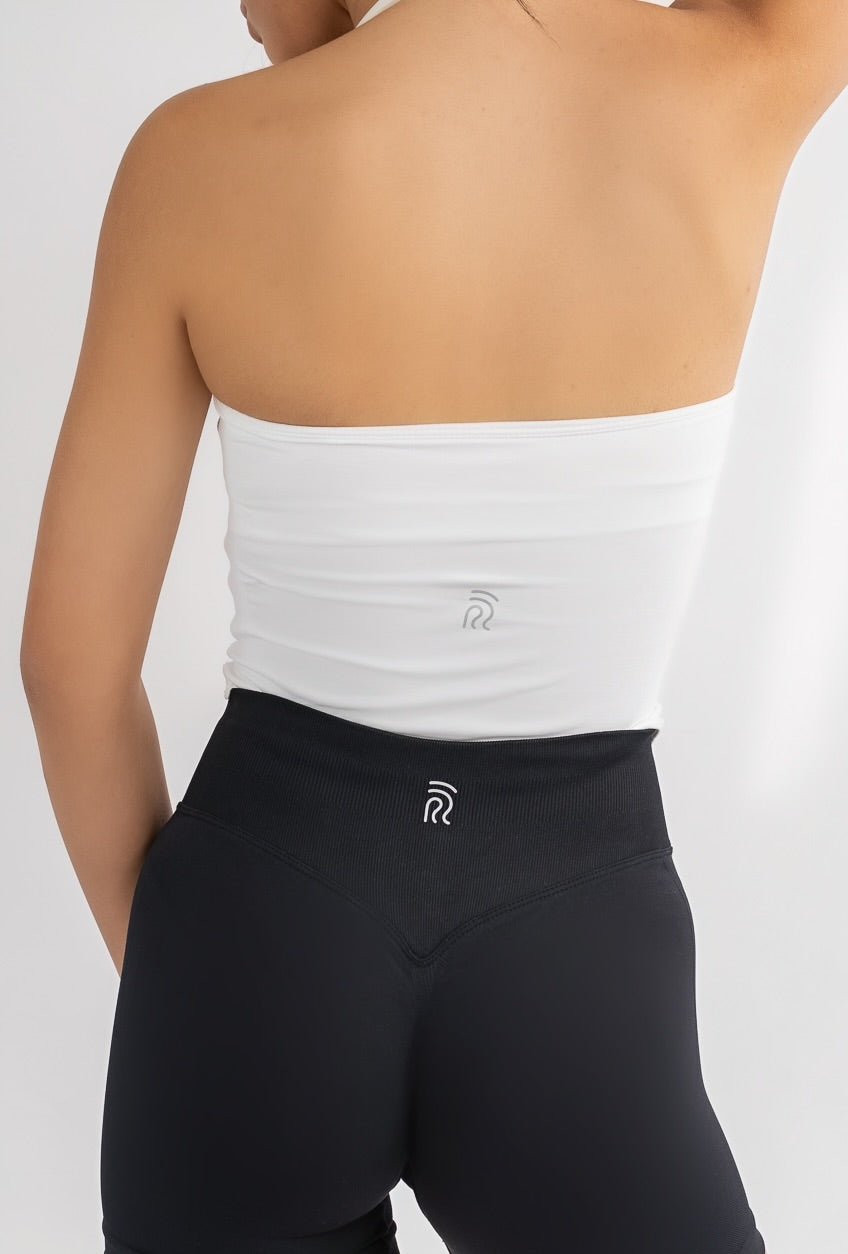 דוגמנית לובשת גופיית ספורט מחטבת בצבע לבן דגם EMBER של YARA